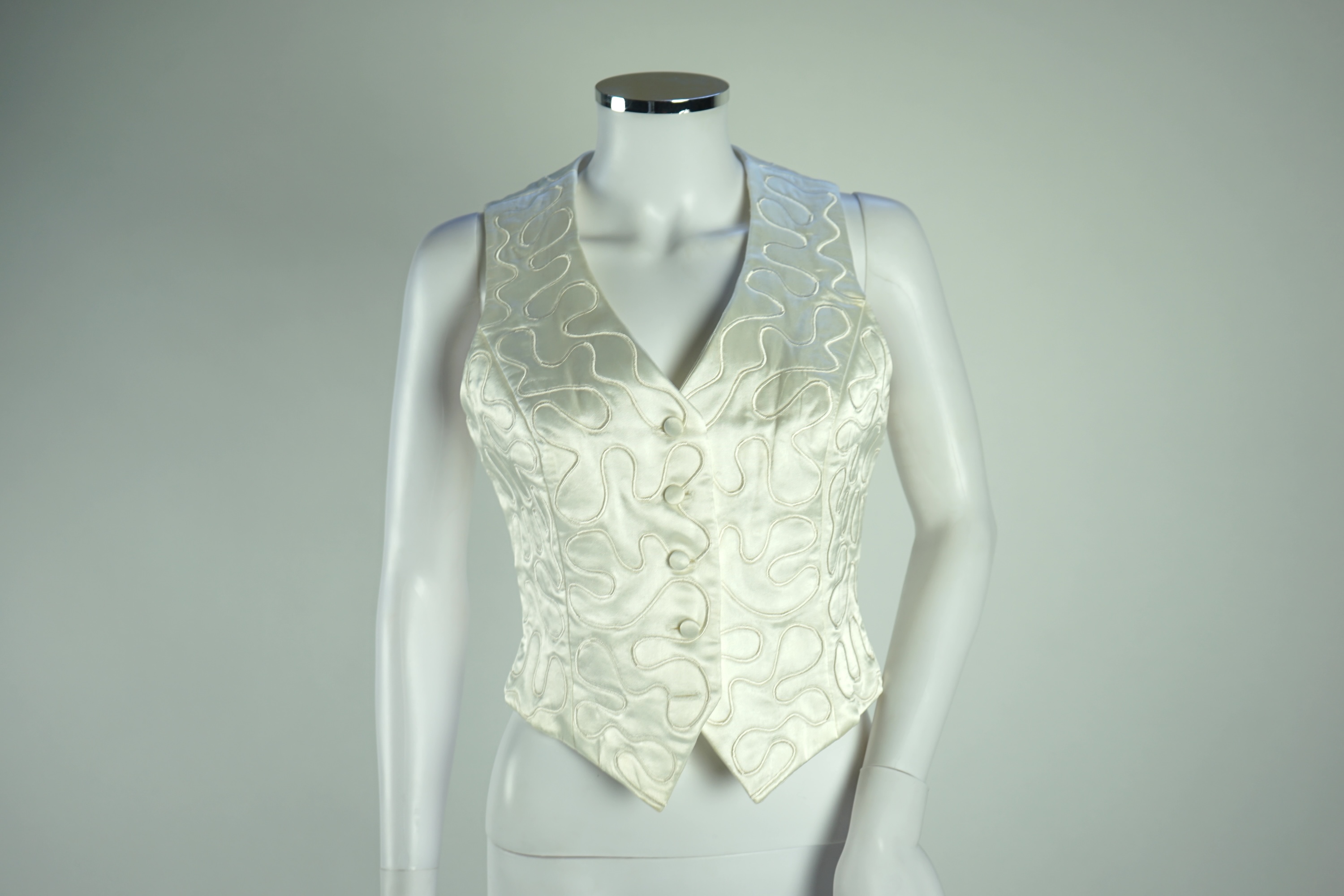 A Diane von Furstenberg cream silk lady's blouse with rope detail, a Dusk for Frank Usher cream silk waistcoat and a white cotton shirt, size 10